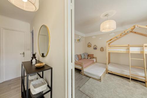 une chambre avec un lit superposé et un miroir dans l'établissement La maison du bonheur - CDG & parc des expos - piscine privée, à Villepinte