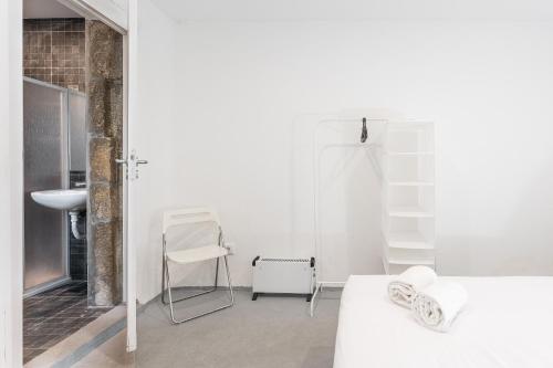 ein weißes Zimmer mit einem Waschbecken, einem Tisch und Stühlen in der Unterkunft Sao Victor Suites in Porto