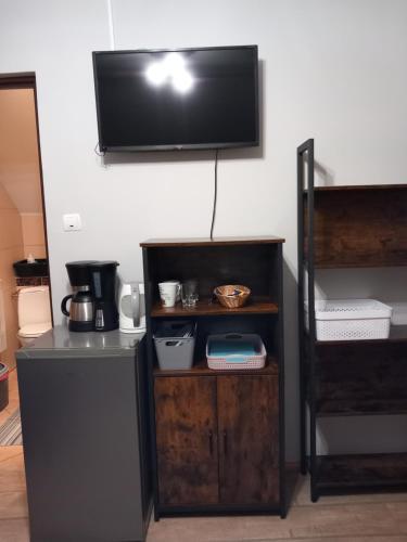 a room with a tv on the wall and a shelf at Dom gościnny u Krupów in Polańczyk