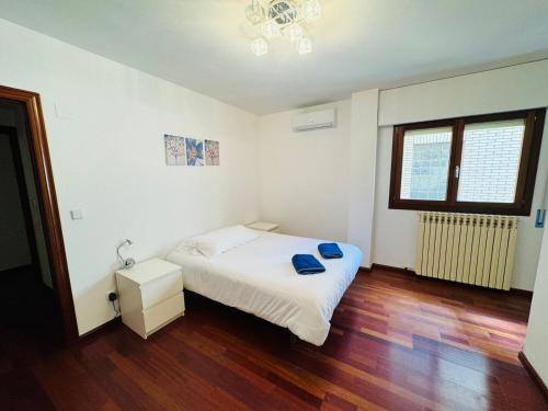 una camera con letto bianco e pavimento in legno di EL TEMPLE a Saragozza