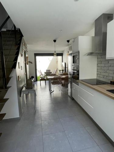 une cuisine avec un escalier et une salle à manger dans l'établissement Whalecome Camargue, à Aigues-Mortes