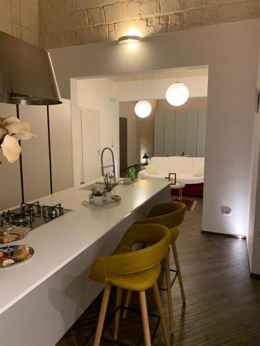una cocina con encimera y algunas sillas y una habitación en Al centro exclusive apartment, en Brindisi