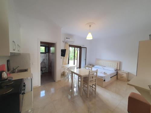 a kitchen and a living room with a bed and a table at Mihal Suites in Sarandë