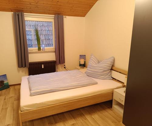 a bed in a small room with a window at Ferienwohnung an den Itzauen in Großheirath