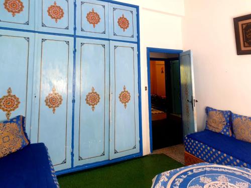 a room with a blue cabinet and a bed and a door at Casa Plasa Grande chefchaouen in Chefchaouene