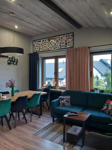 a living room with a green couch and a table at Dom gościnny u Krupów in Polańczyk