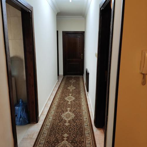 a hallway with a rug in front of a door at Khamis Apartment in Amman