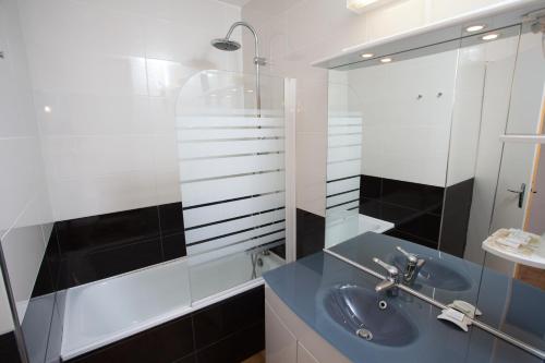 a bathroom with a blue sink and a shower at Hotel Les Dunes in Marseillan