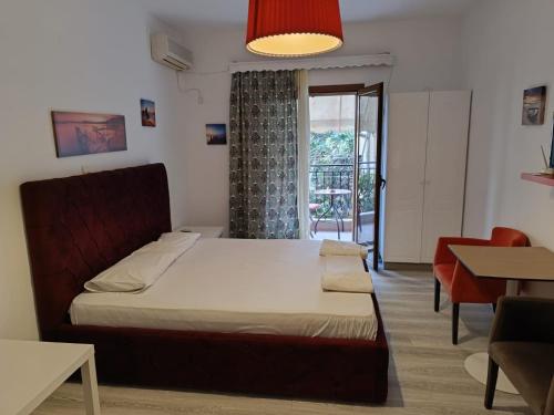 um quarto com uma cama, uma mesa e uma janela em Apartment Rina em Sarandë