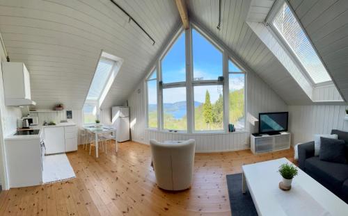 a living room with an attic with large windows at Fjord road in Hjelmeland
