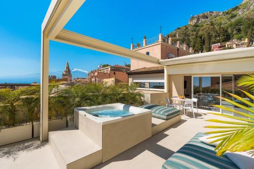 uma banheira de hidromassagem na varanda de uma casa em Taormina Infinity Suites em Taormina