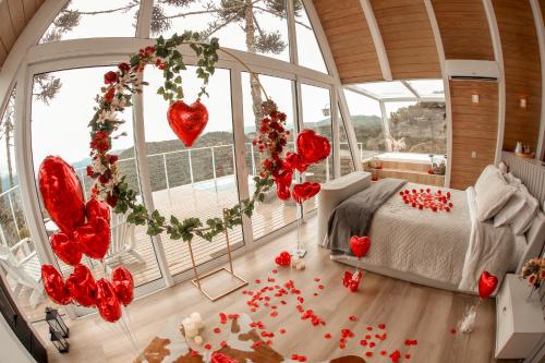 a bedroom with a bed and areath of red hearts at Chalé Aframe- Benta Rosa Chalés de Luxo in Urubici