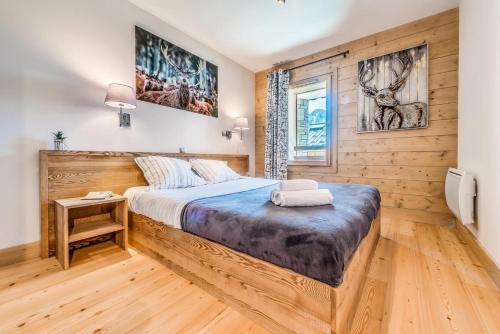 une chambre avec un lit et un mur en bois dans l'établissement Résidence Les Balcons EtoilÉs - Appartement 4 au pied des pistes MAE-3374, à Champagny-en-Vanoise