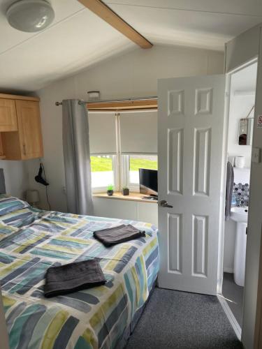 ein Schlafzimmer mit einem Bett mit zwei Handtüchern darauf in der Unterkunft JSNHolidays@CraigTara in Ayr