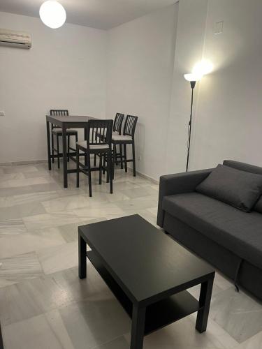- un salon avec un canapé, des tables et des chaises dans l'établissement La Casa del Tambor, à Cordoue