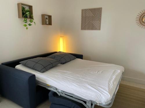 un lit avec deux oreillers dessus dans une chambre dans l'établissement L’Odyssée, à Blonville-sur-Mer