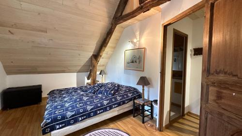une chambre avec un lit dans une pièce avec des plafonds en bois dans l'établissement La Baudonnière, à Les Chambres