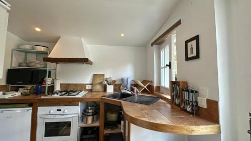 - une cuisine avec un comptoir, un évier et une cuisinière dans l'établissement La Baudonnière, à Les Chambres