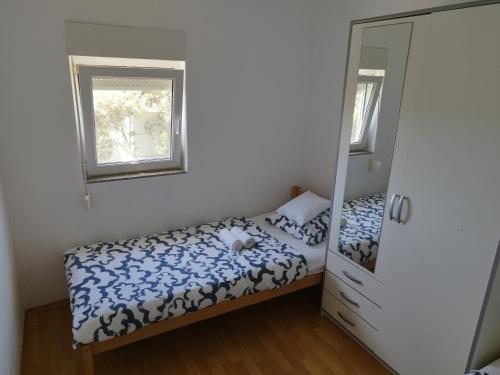 a small bedroom with a bed and a mirror at Summer cottage with breathtaking view in Zečevo Rogozničko