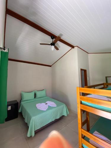 1 dormitorio con cama verde y ventilador de techo en Pousada Pedra Grande - SANA, en Macaé