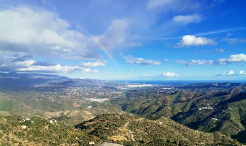 a view of a mountain range with a rainbow in the sky at Hotel Rural Verde Oliva in Comares