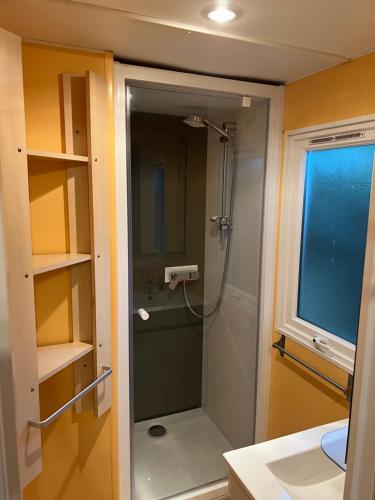 une salle de bain avec une douche avec une porte vitrée dans l'établissement La Teranga, à La Roque-dʼAnthéron