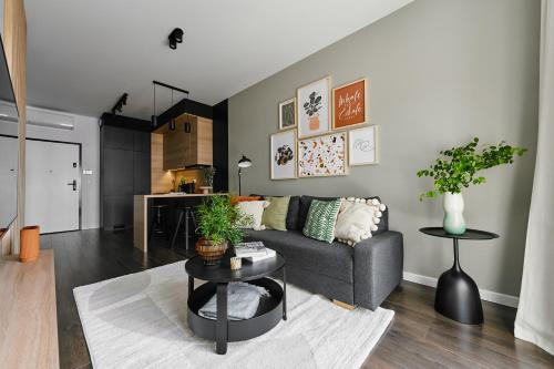 a living room with a couch and a table at Cracow Palm Apartment in Kraków