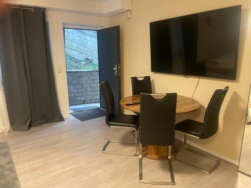 ein Esszimmer mit einem Tisch, Stühlen und einem TV in der Unterkunft Ferienwohnung Panoramablick in Sinsheim