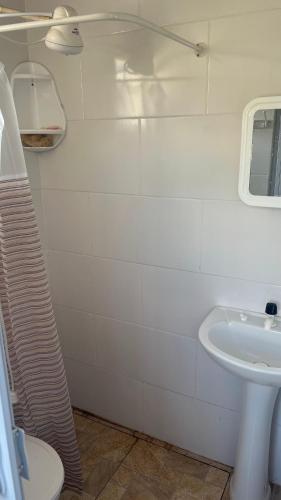 a white bathroom with a sink and a toilet at Apê do NADINHO in Caparaó Velho