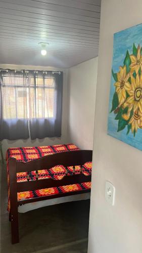 a bedroom with a bunk bed with a painting on the wall at Apê do NADINHO in Caparaó Velho