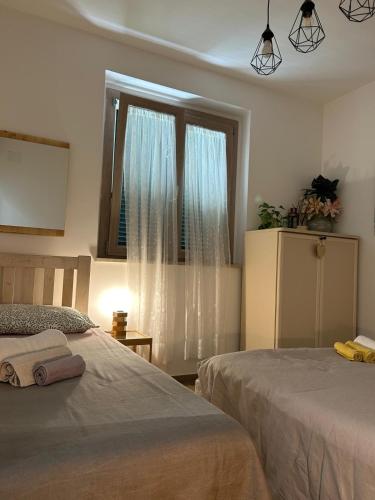 a bedroom with two beds and a window at Il Giardino di Limoni in Marino