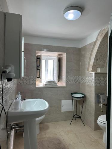 a bathroom with a sink and a toilet at Il Sogno Apartments in Alberobello