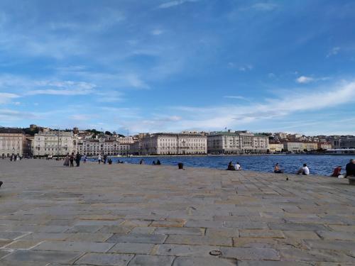 a group of people sitting on a pier next to the water at Blu Trieste in Trieste