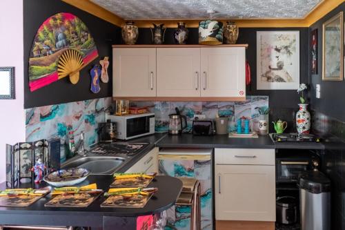 a kitchen with white cabinets and a counter top at Oriental Belle Aire in Hemsby