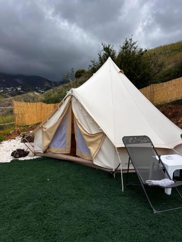a white tent with a chair and a table at Glamping Finca el Olivo in Mijas