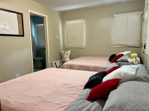 a bedroom with two beds with red and white pillows at Couture Themed 3 Bedroom in Prime Spot with Patio, Parking, Fireplace, Pets Welcome in Chicago