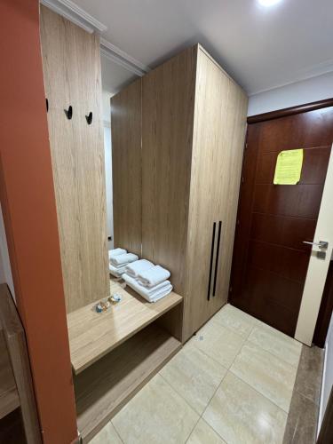 a bathroom with a wooden cabinet with folded towels at Hotel Lyhnidas in Pogradec