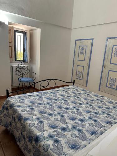 a bedroom with a bed with a blue and white bedspread at Il Sogno Apartments in Alberobello