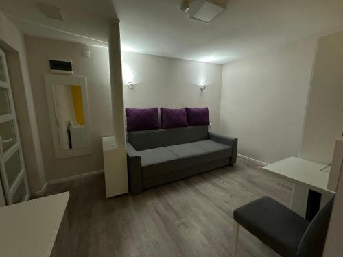 a living room with a couch and purple pillows at Vila Storia in Niš