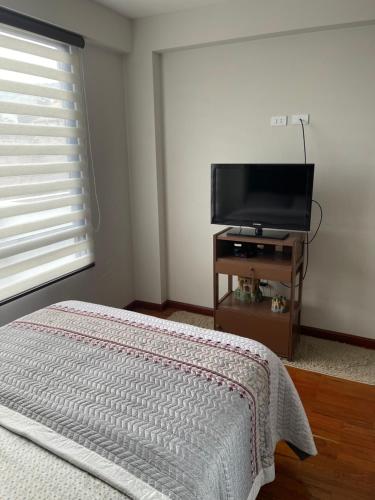 Schlafzimmer mit einem Bett und einem Flachbild-TV in der Unterkunft Habitación en Casa Loma in Cochabamba