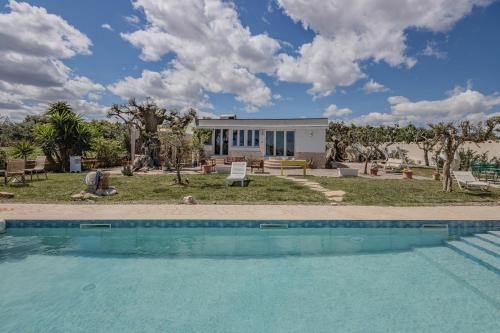 una villa con piscina di fronte a una casa di Extravacanza Polignano a Mare a Polignano a Mare
