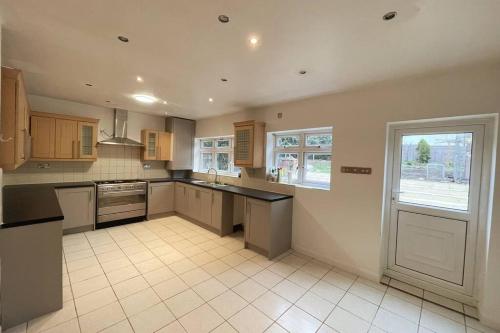 a large kitchen with a counter and a window at Modern Spacious 4-Bed House in London