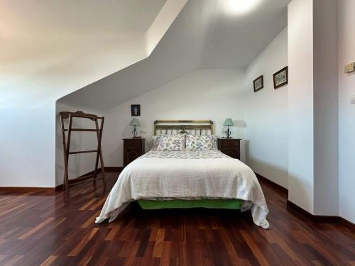 1 dormitorio con 1 cama, 2 mesitas de noche y una escalera en Vendaval, en Muxía