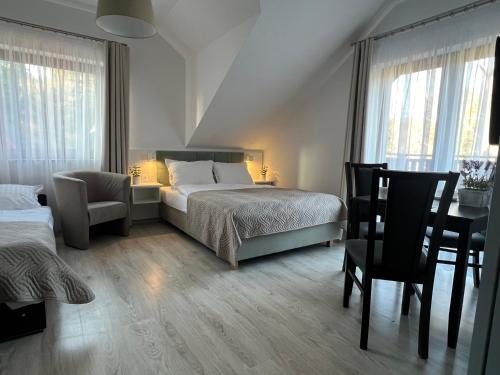1 dormitorio con cama, escritorio y silla en Ostoja, en Dębki