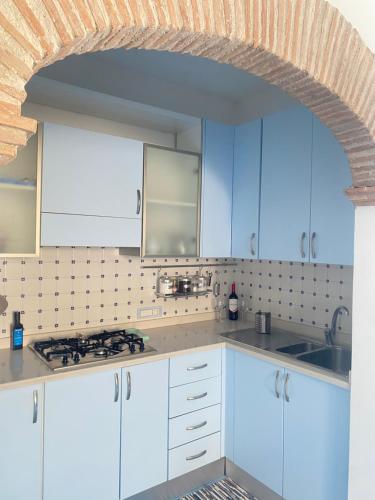 a kitchen with white cabinets and a brick wall at Casa Tasca in Ravello