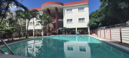 a swimming pool in front of a building at Ashiana OceanSide Apartment in Flic-en-Flac