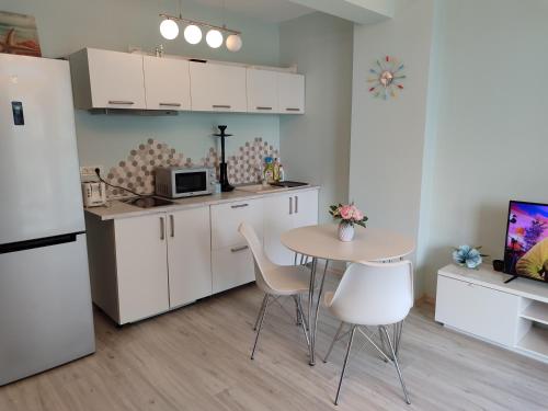 a kitchen with a table and chairs and a refrigerator at Nord Residence in Mamaia Nord
