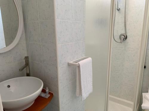 een witte badkamer met een wastafel en een douche bij Hotel Conte in Ischia