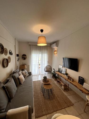 a living room with a couch and a tv at Light Blue in Perea