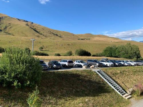 Un tas de voitures garées dans un parking dans l'établissement Joli appartement 6 personnes La Toussuire, à La Toussuire